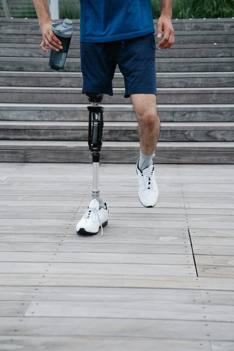 A person with a prosthetic leg walking confidently on a wooden path, promoting mobility and body positivity.